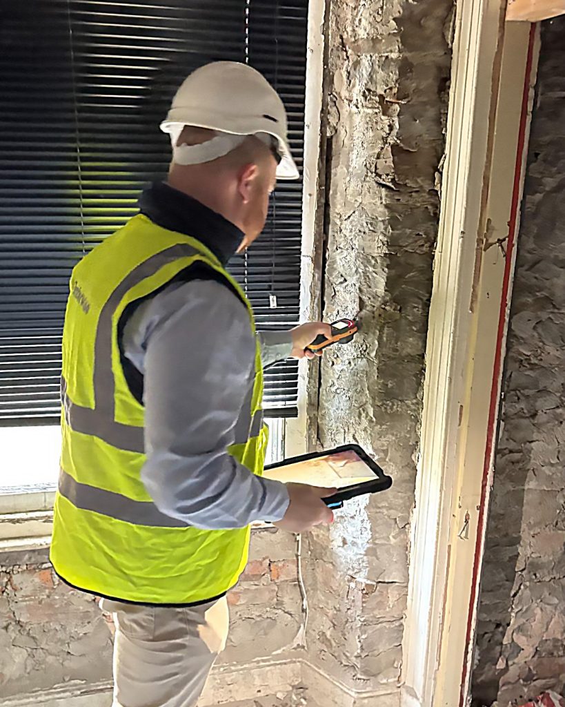Timberwise surveyor inspecting damp in building in Cardiff