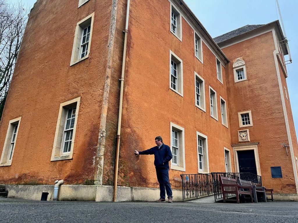 Timberwise surveyor inspecting damp wall of building in Dunfermline