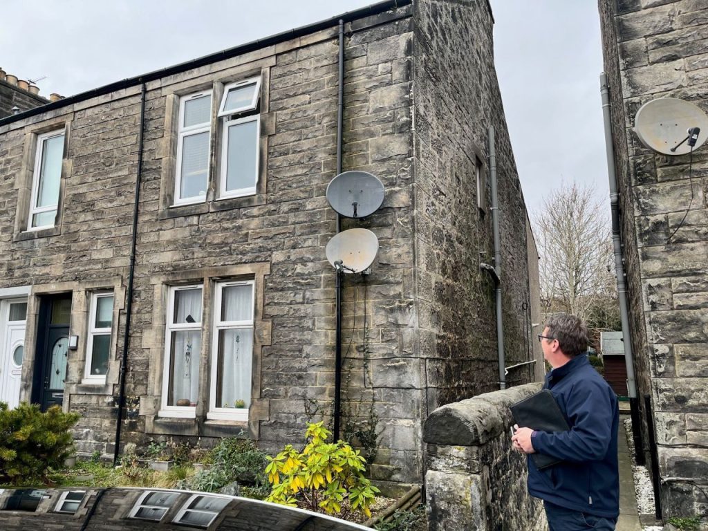 Timberwise Surveyor inspecting stone house exterior in Musselburgh