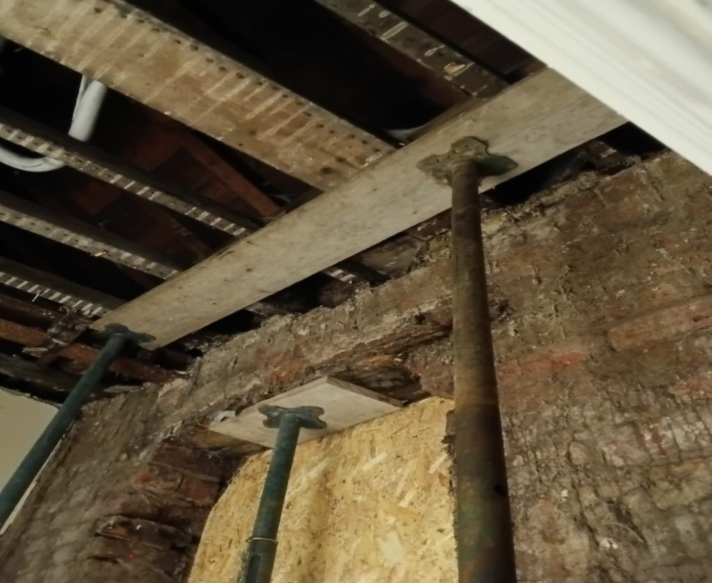 Exposed beams with supporting props visible.
