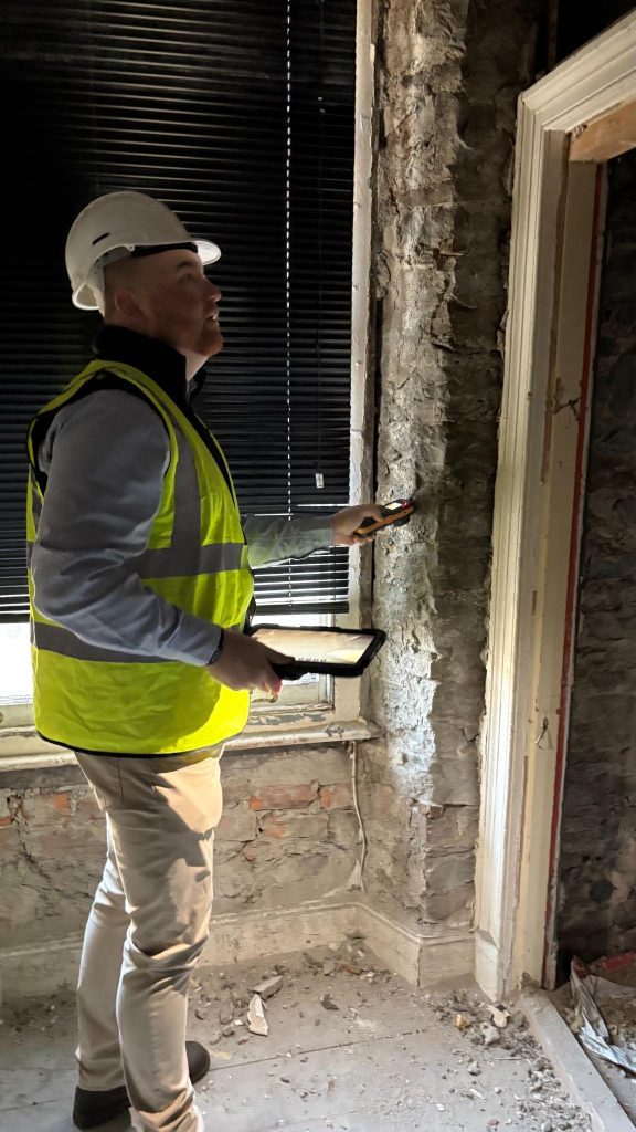 Lintel Damage Symptoms: How to Spot It Early 1 A surveyor assessing a door frame and lintel