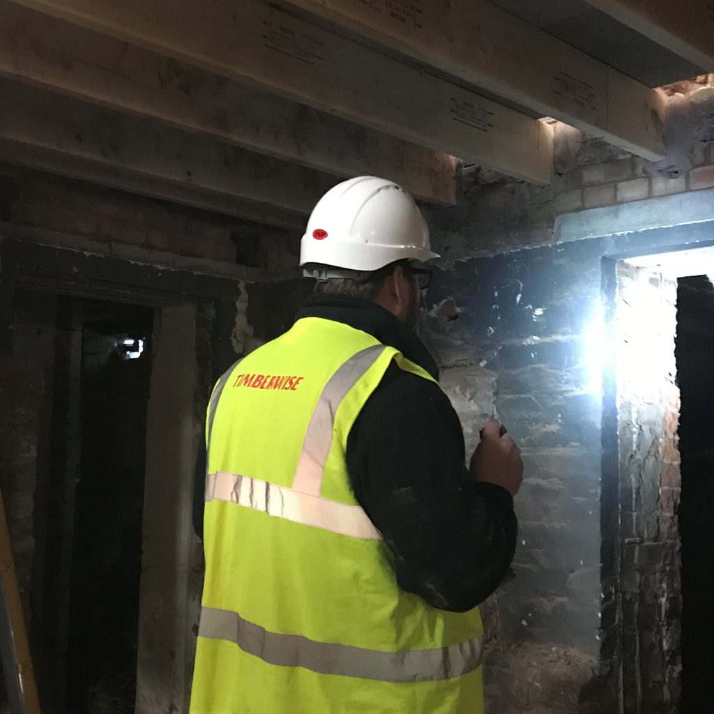 Commercial Structural Repair Surveys in London: What They Include & Why They Save Money 1 a surveyor in PPE examining a basement