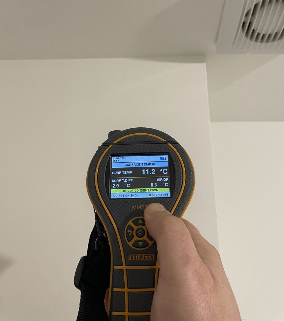 Handheld device displaying surface temperature of a wall with condensation issues in Newcastle