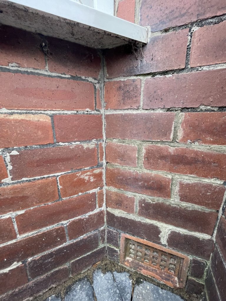 Brick wall with cobwebs and vent