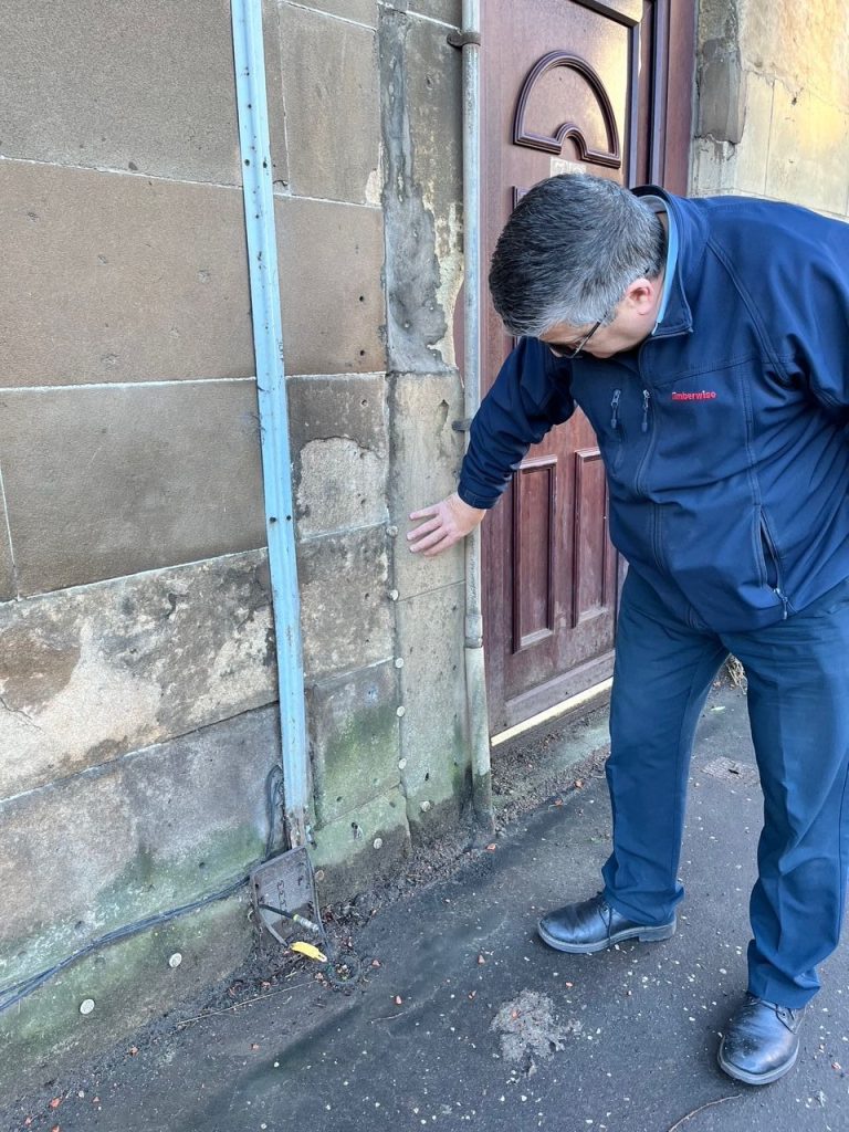 Timberwise surveyor inspecting damp external wall in Glasgow