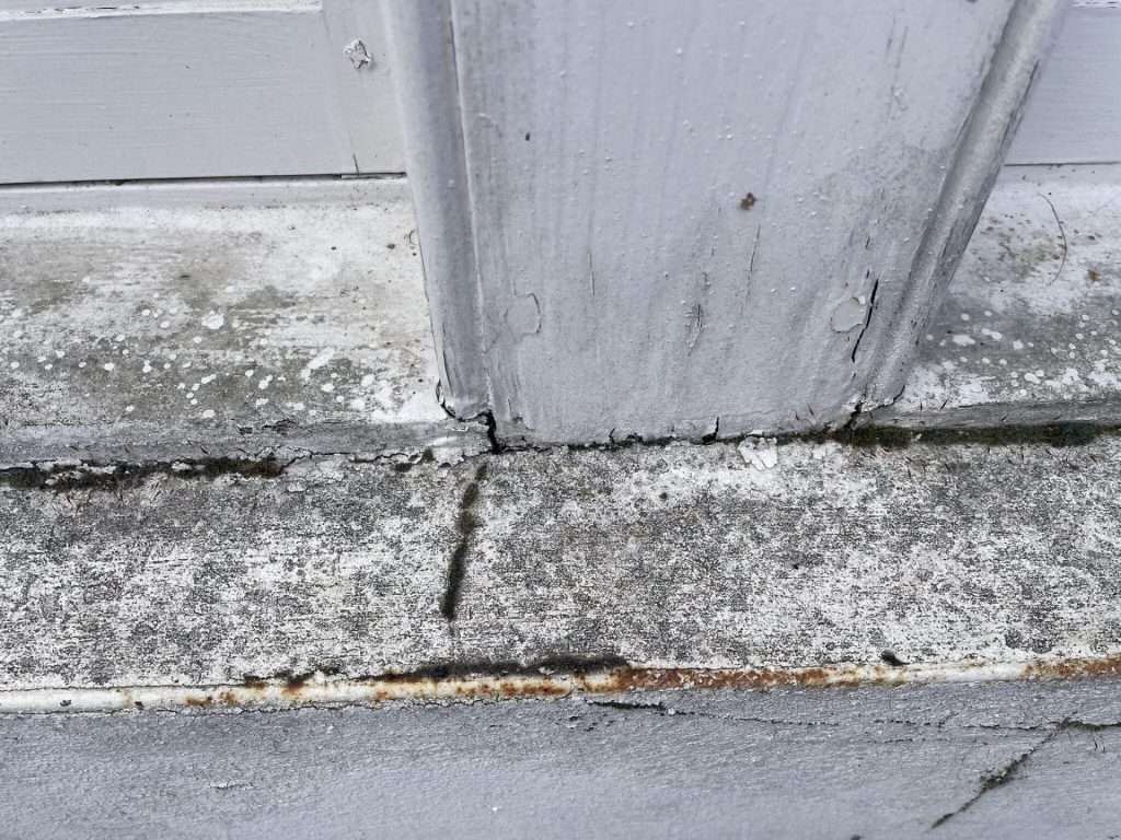 Why Timber Windows Rot and How to Prevent It 1 A gap in a window frame with damp staining