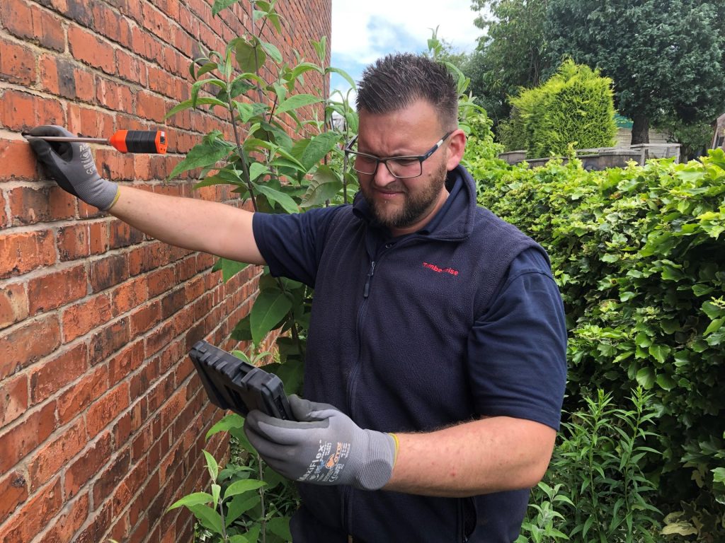 Wall Tie Failure and Structural Damage: What You Need to Know 3 A surveyor using a metal detector to plot the position of existing wall ties